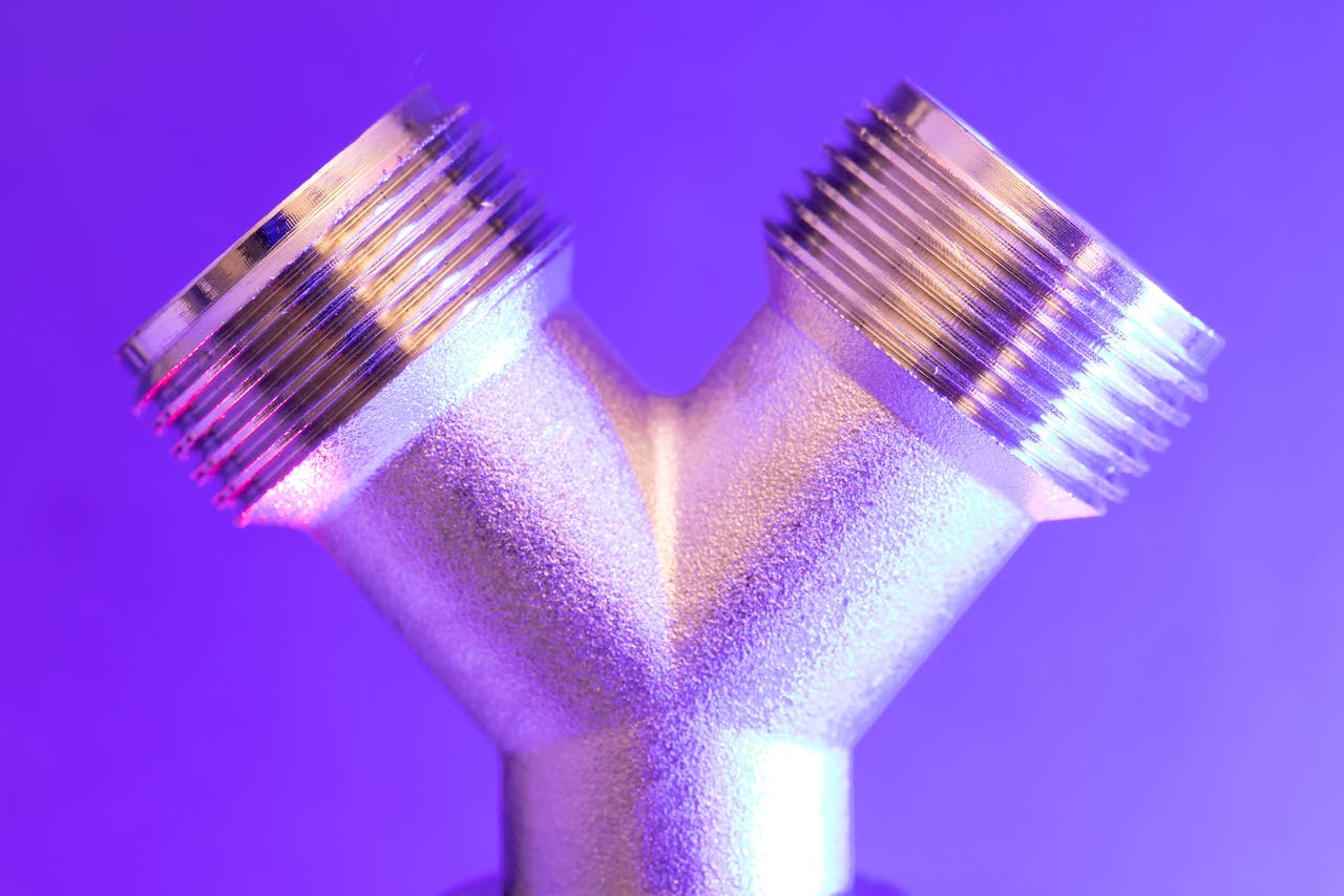 Close-up of a chrome metal pipe with vibrant lighting, showcasing industrial design.